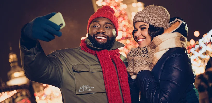 two people taking a selfie wearing logod jackets