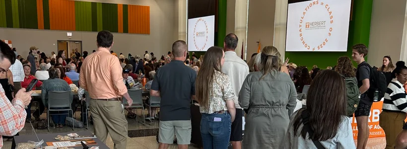 A group of people standing in front of a large crowd