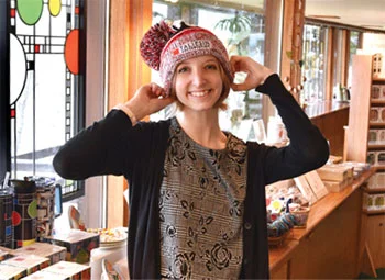 person trying on a logoed hat inside a gift shop