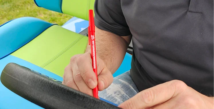 person sitting on a golf cart writing with a pen