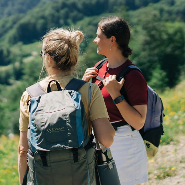 two people on a hike carrying backpacks