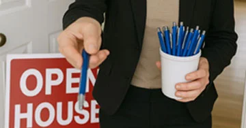 real estate agent handing out personalized pens