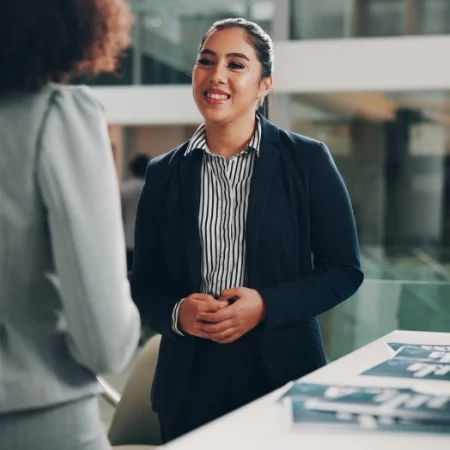 Two people talking at a booth during a trade show.