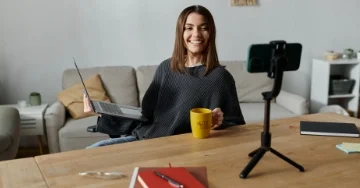 Smiling influencer taking a picture with a sponsored product.