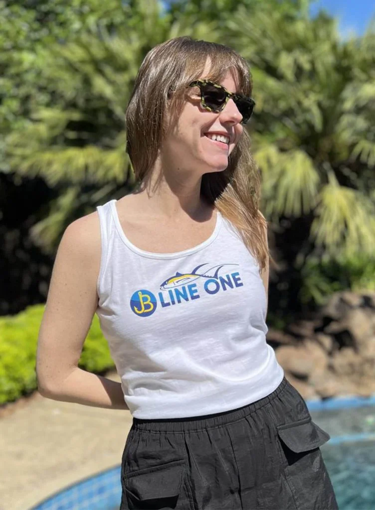 Woman wearing a company branded fishing tank top in front of a pool.