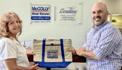 McColly Real Estate keeps agents focused on the future - photo of two employees holding branded tote bag