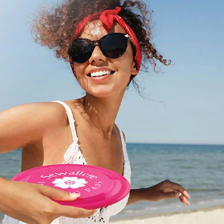 person at beach throwing branded sport flyer