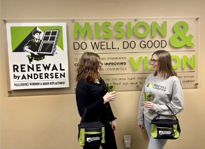 two people holding logoed drinkware