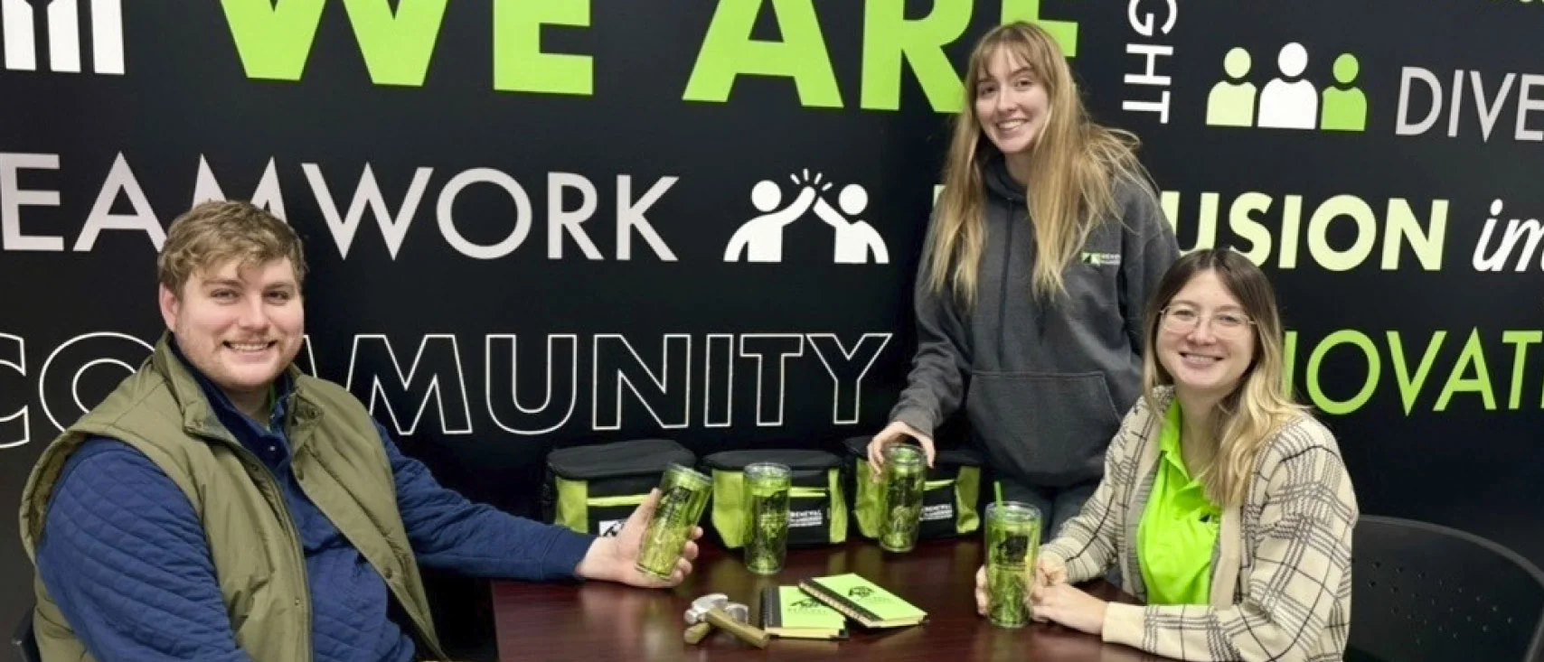 Group of people sitting at a table surrounded by custom swag