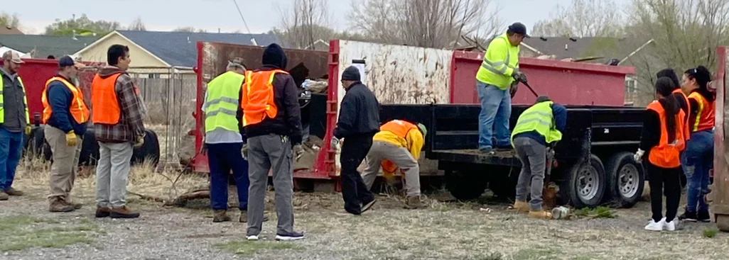 a dozen of community volunteers clearing out collected trash and recycling