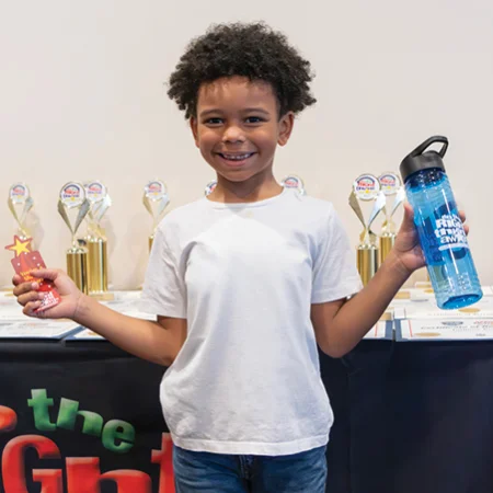 child holding an award and water bottle