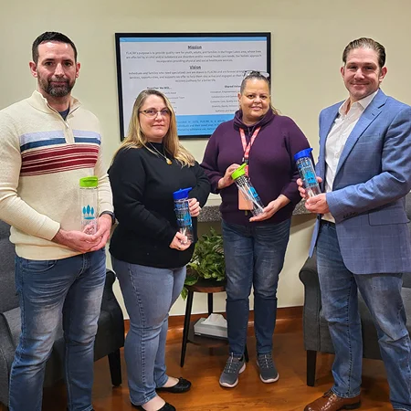 group of employees holding various promotional gifts