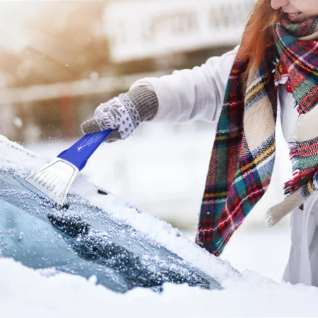 A person removing snow from a car