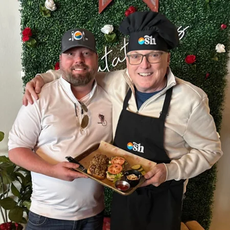 Two men holding a tray of food