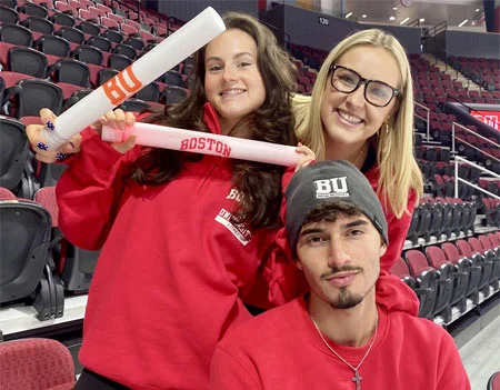 A group of people posing for a photo holding cheer sticks wearing beanies
