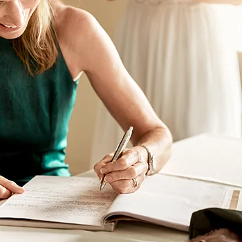 A women writing in a notebook with a custom pen