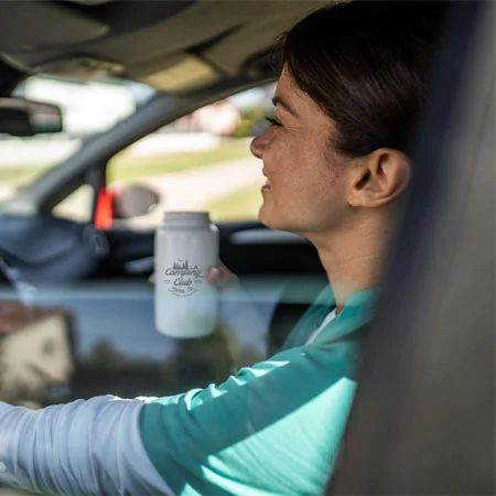 A person holding a bottle in a car