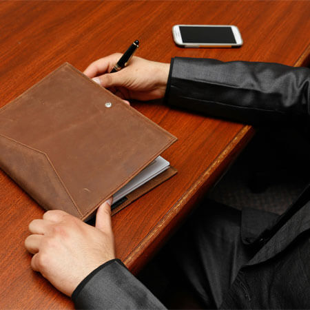 Person Holding Brown Leather Book