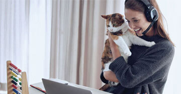 person holding a cat looking at a computer