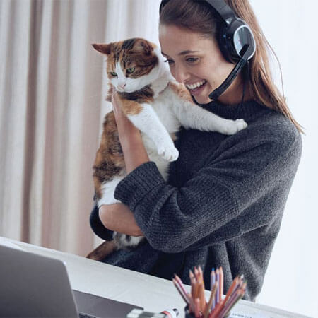 person holding a cat looking at a computer