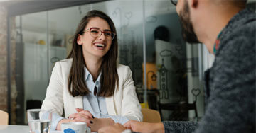 two people talking with a cup of coffee