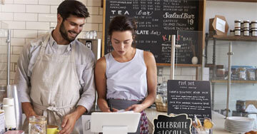 two people working behind a business counter