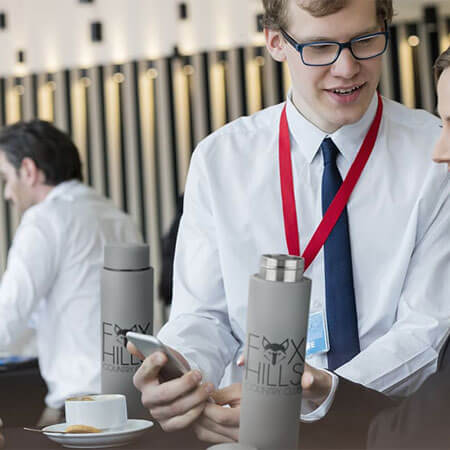 two people talking next to imprinted bottles