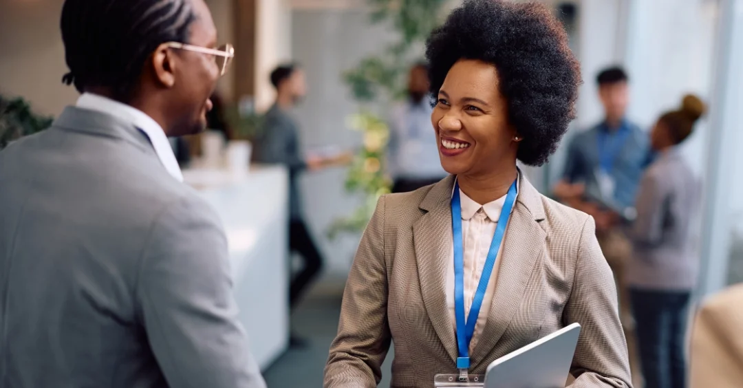 People networking and shaking hands at a trade show.