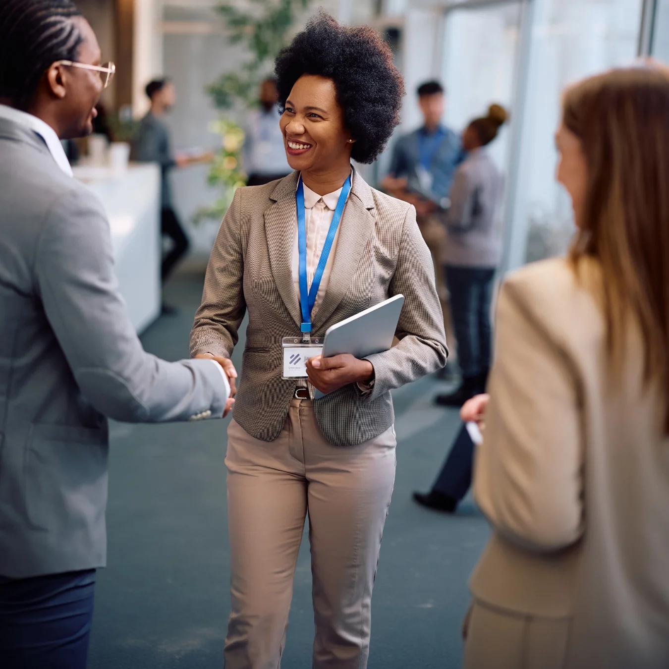 People networking and shaking hands at a trade show.