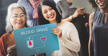 two people holding up a blood drive sign