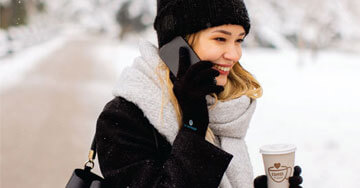 person holding a cup of coffee talking on the phone