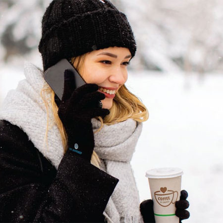 person holding a cup of coffee talking on the phone