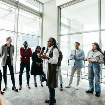 Team leader standing in the middle of a circle of people during a team building exercise at a staff retreat. 