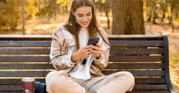 person sitting on a bench holding a phone