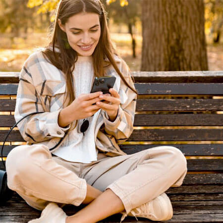 person sitting on a bench holding a phone