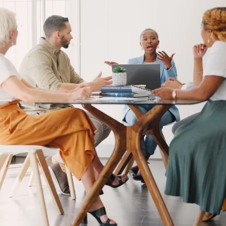 Group of workers sitting around a conference table discussing a strategic plan.