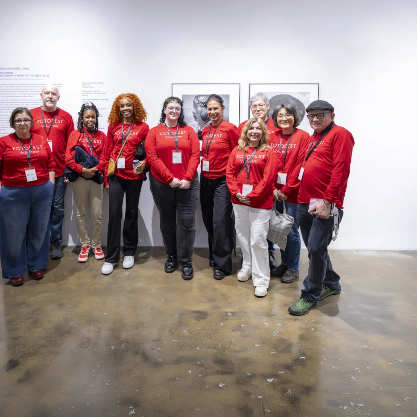 Smiling group of people wearing matching branded T-shirts and lanyards.