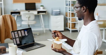 person sitting at a table eating noodles