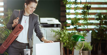 person carrying a yoga mat looking at a computer